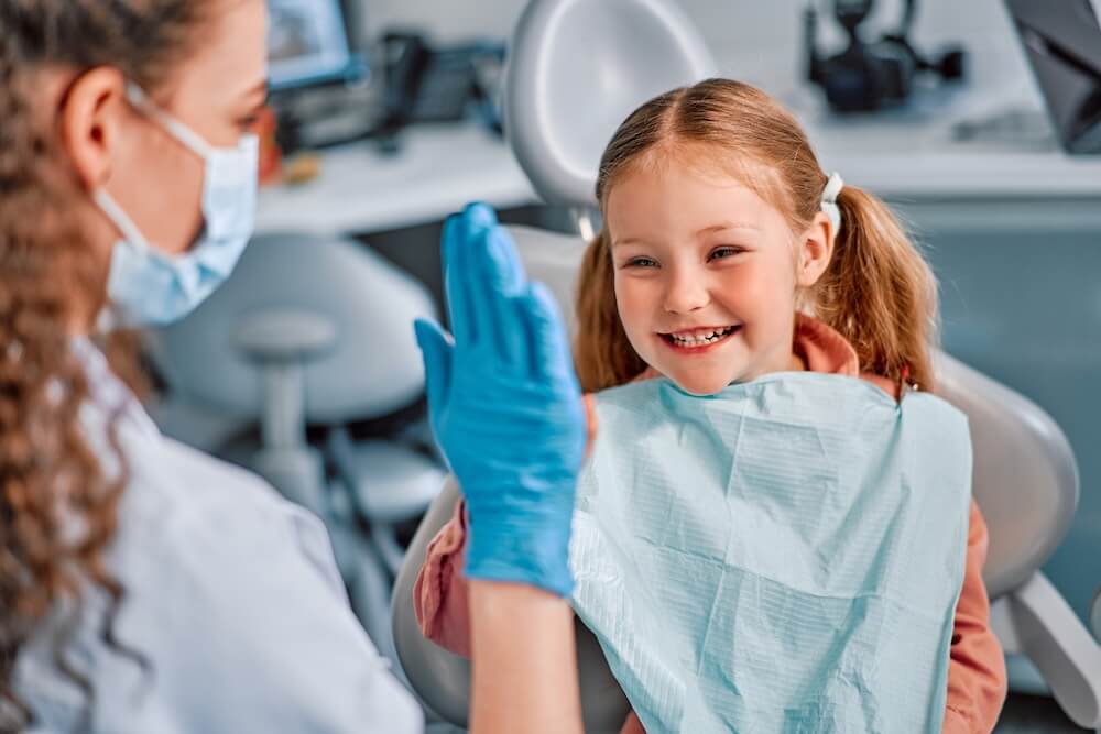 smiling child giving high five to orthodontist